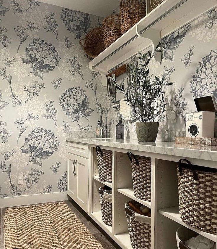 a bathroom with floral wallpaper and baskets on the counter