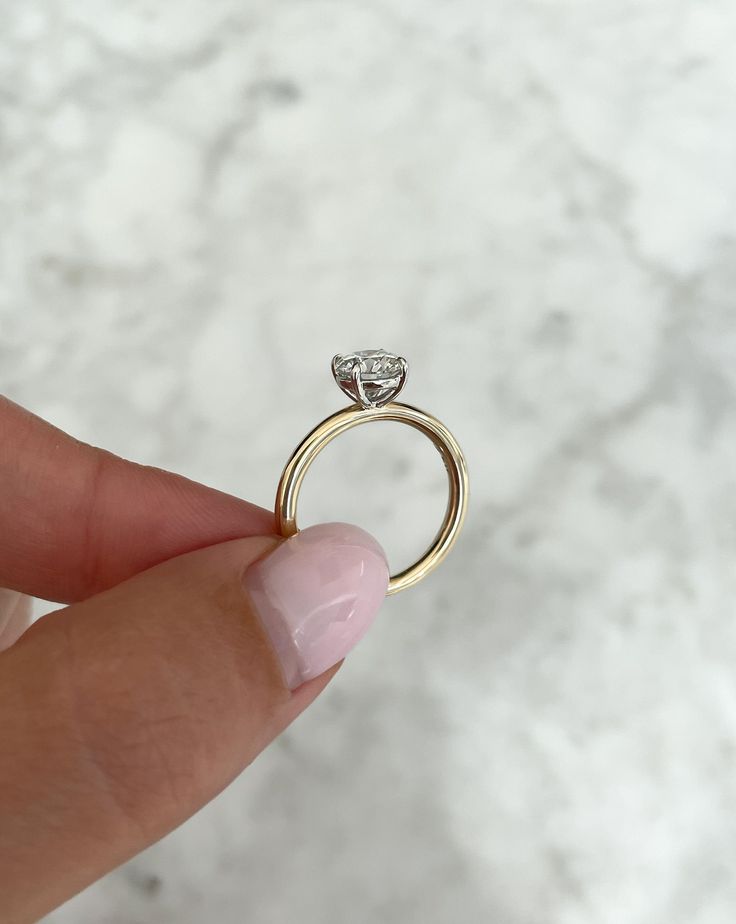 a person holding a ring with a diamond on it