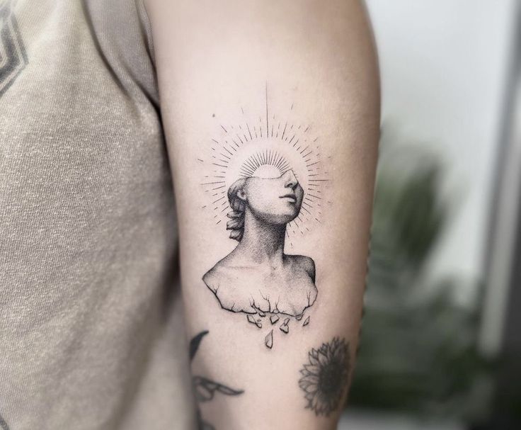 a woman's arm with a tattoo on it and a sun above her head