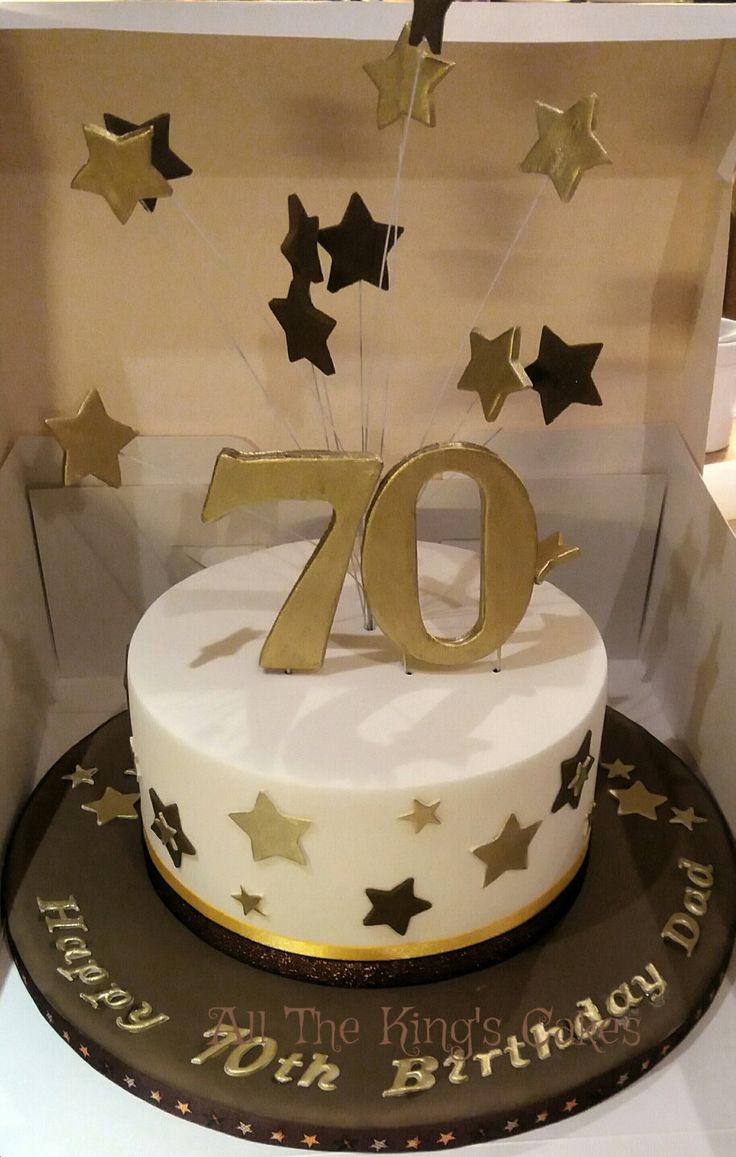 a white cake with gold stars on top in a box for the 70th birthday party