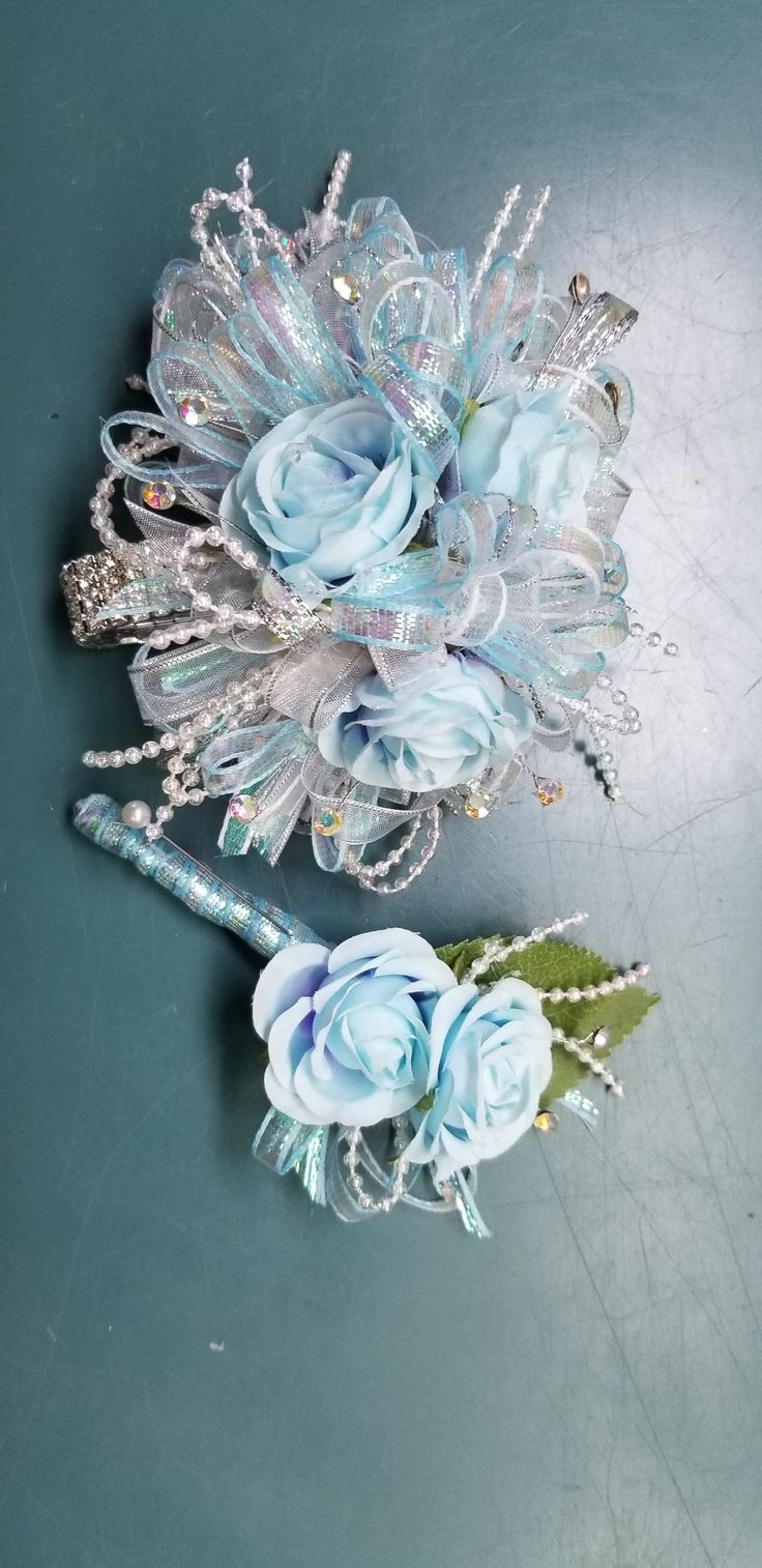 two blue flowers are sitting next to each other on a table with silver and crystal accents