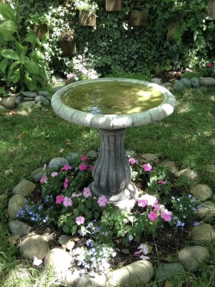 a bird bath sitting in the middle of a garden