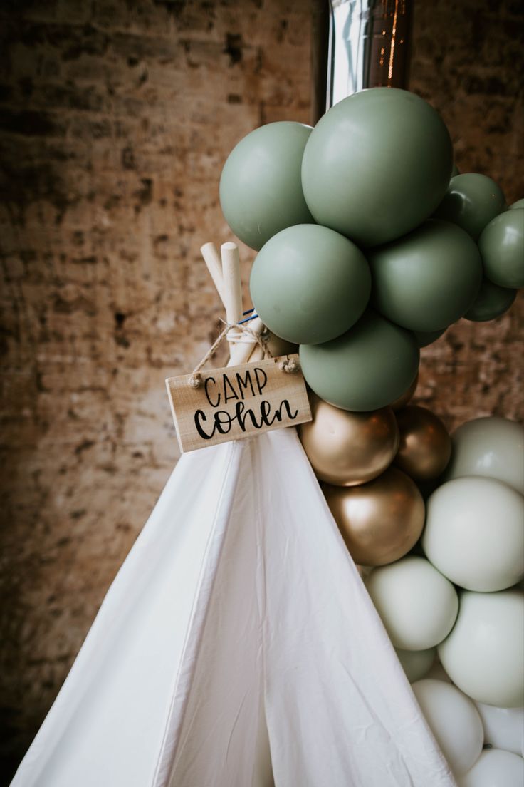 a teepee tent with some balloons and a sign that says camp cone on it