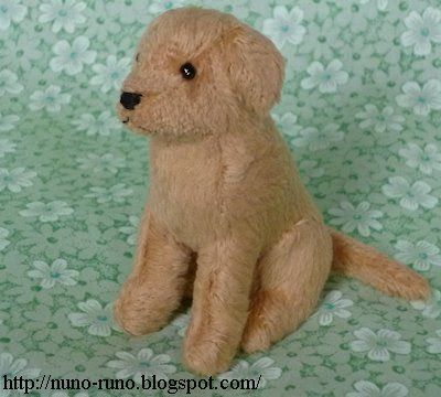 a small stuffed dog sitting on a green and white background