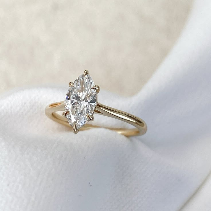 a diamond ring sitting on top of a white cloth