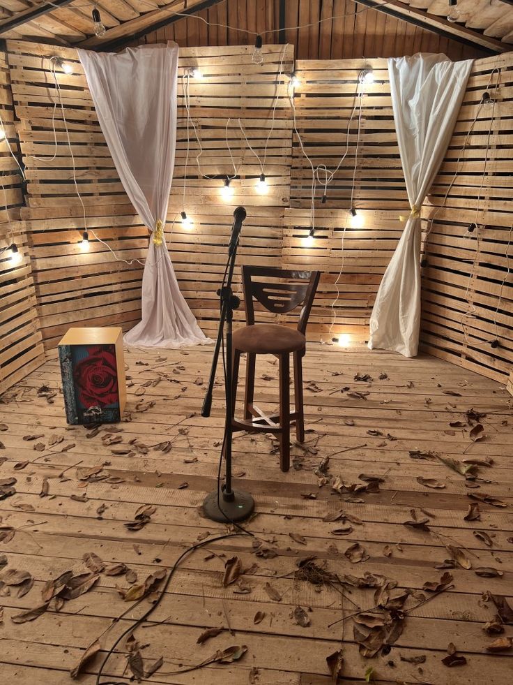 a room that has some lights on the ceiling and a chair with a microphone in it