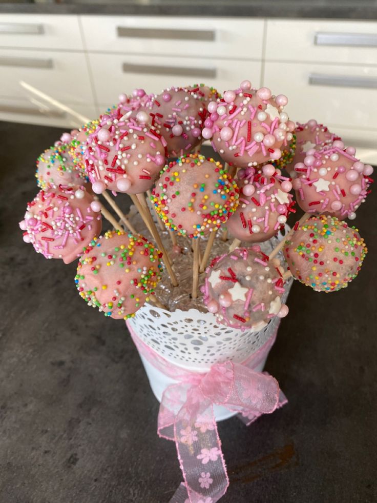 a bouquet of pink and white candies with sprinkles in a vase