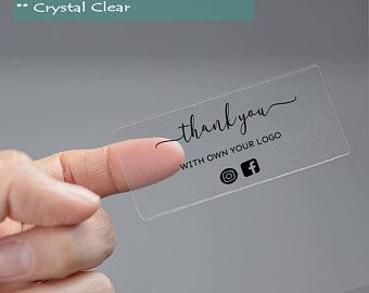 a hand holding a clear plastic business card with the words thank you written on it