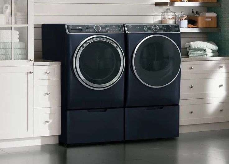 the front load washer and dryer are next to each other in this kitchen