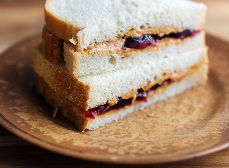 two slices of toasted sandwich sitting on top of a brown plate with cranberry sauce