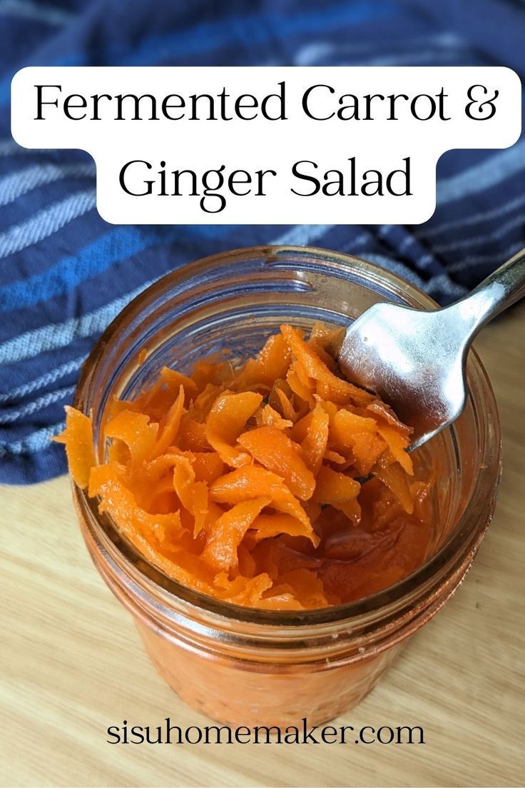 a glass jar filled with carrots on top of a wooden table