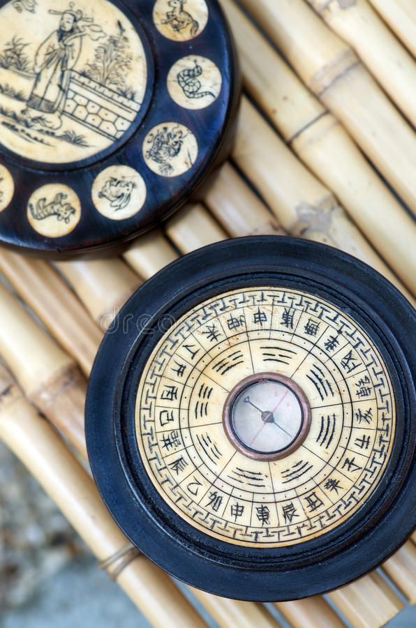 two black and gold plates sitting on top of a bamboo mat