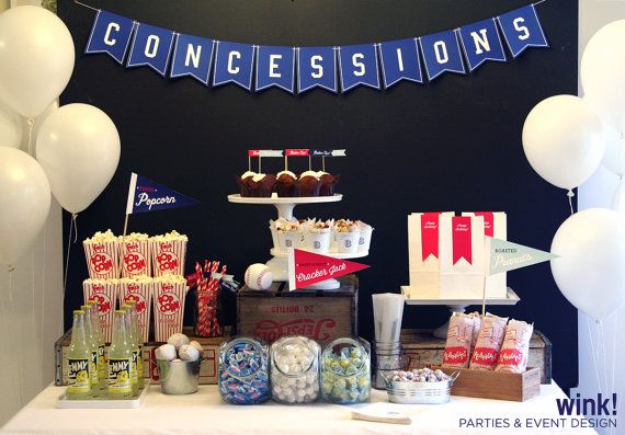 a table with balloons and confections on it at a party or event in front of a black wall