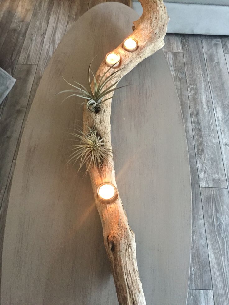 a table with some lights on it and a tree branch in the middle that is shaped like a heart