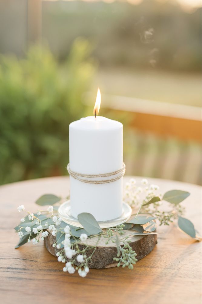 a white candle sitting on top of a wooden table