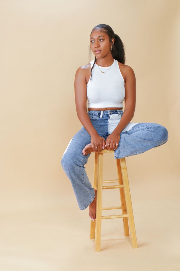 a woman sitting on top of a wooden stool