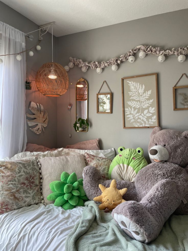 there is a teddy bear on the bed with other stuffed animals in front of it