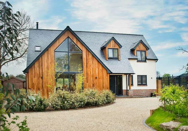 a large house with a driveway leading up to it and lots of greenery in front