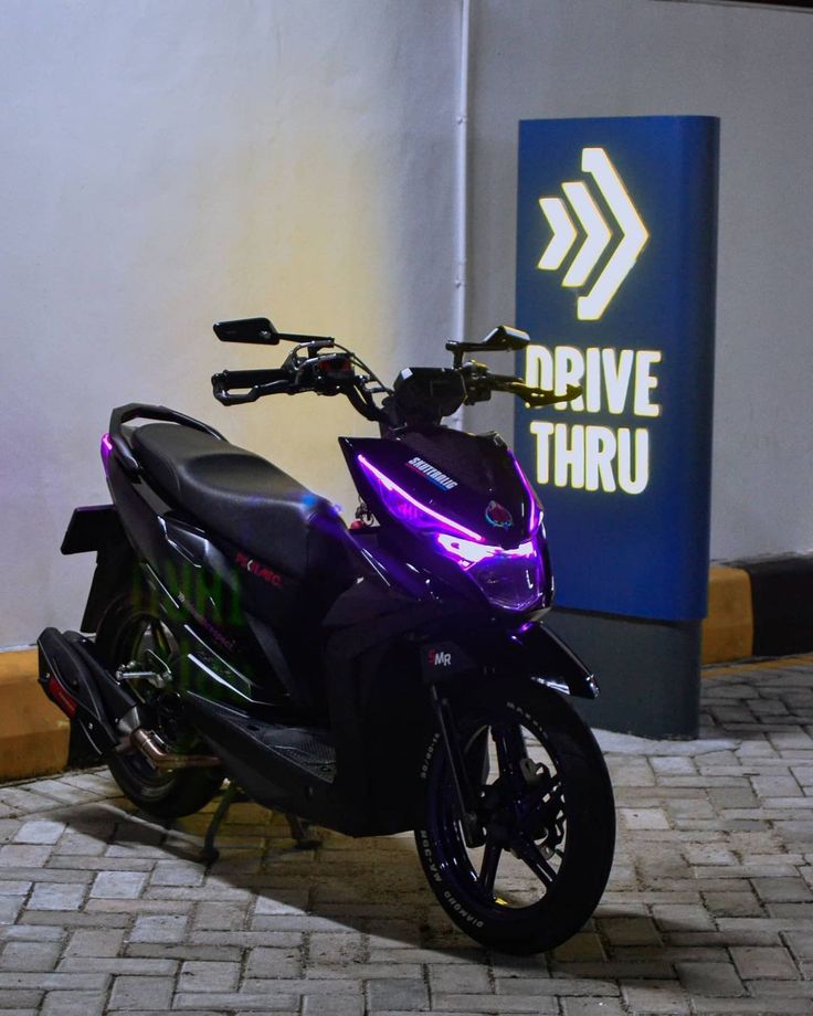 a purple motorcycle parked in front of a drive thru sign