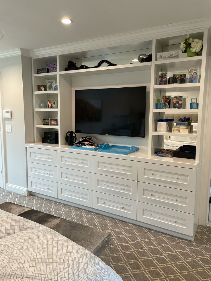 a bedroom with built in entertainment center and bed