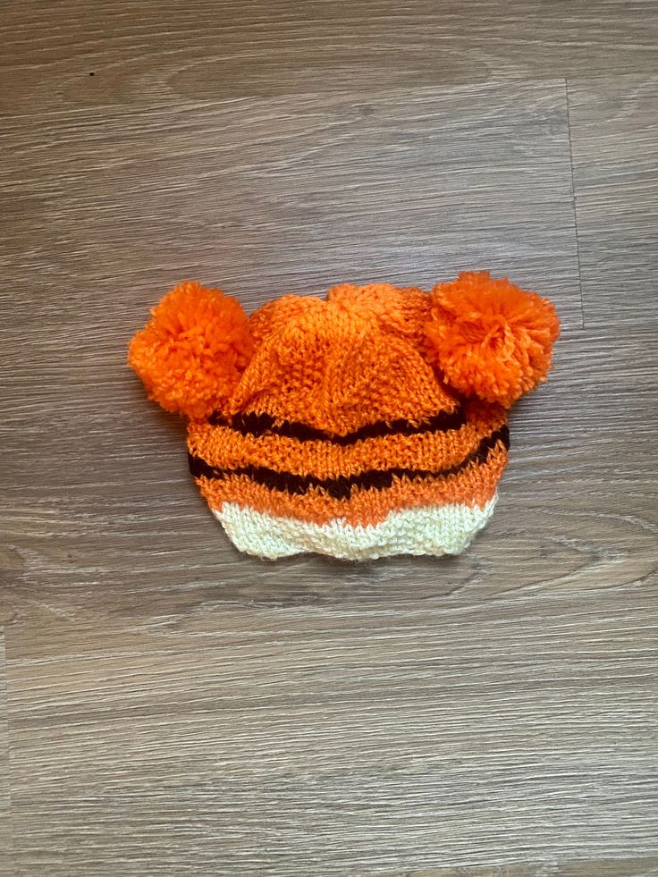 This dark brown and orange tiger striped beanie has a simple pattern that you can boast is handmade! Pair with the adult sized Year of the Tiger beanie (pictured) for an adorable photo op! ~ This is a great knitted cap! It is both warm and comfortable. ~ It is a baby or toddler size hat. It would comfortably fit a head 20 to 22 inches in circumference. Care Instructions: Machine wash warm; tumble dry; do not bleach; do not iron. Like this hat but looking for a different color? Just contact me and I will be happy to make something just for you! One Size Orange Yarn Hat, Handmade Orange Hat One Size, Orange One-size Yarn Hat, Handmade Orange Hats One Size, Handmade One Size Orange Crochet Hat, Handmade Orange Crochet Hat One Size, Handmade Orange Beanie Hat, Handmade Orange Crochet Beanie Hat, Orange Knitted Hat One Size