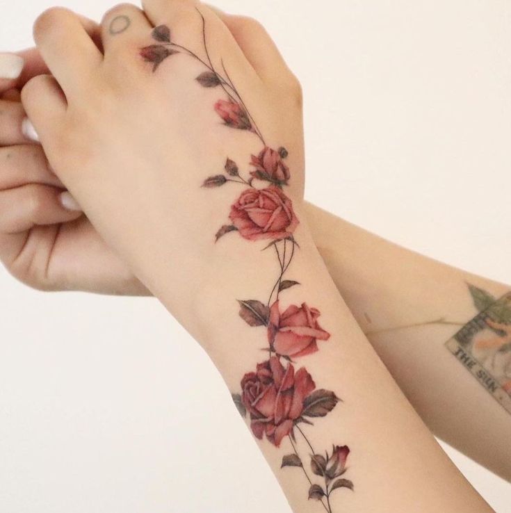 two hands with tattoos that have flowers on them