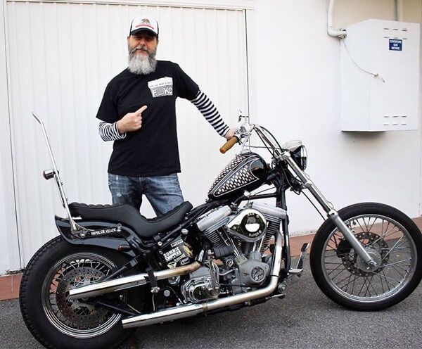 a man standing next to a parked motorcycle