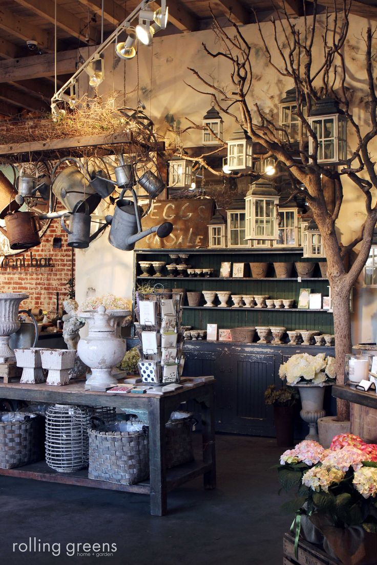 the interior of a flower shop with pots and pans hanging from the ceiling above