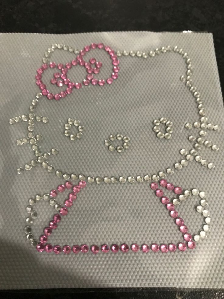 an image of a hello kitty design made out of beads on a piece of plastic