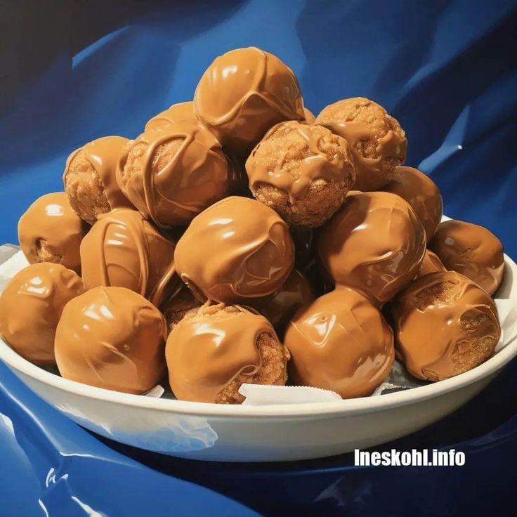 a white bowl filled with lots of chocolate covered candies on top of a blue table