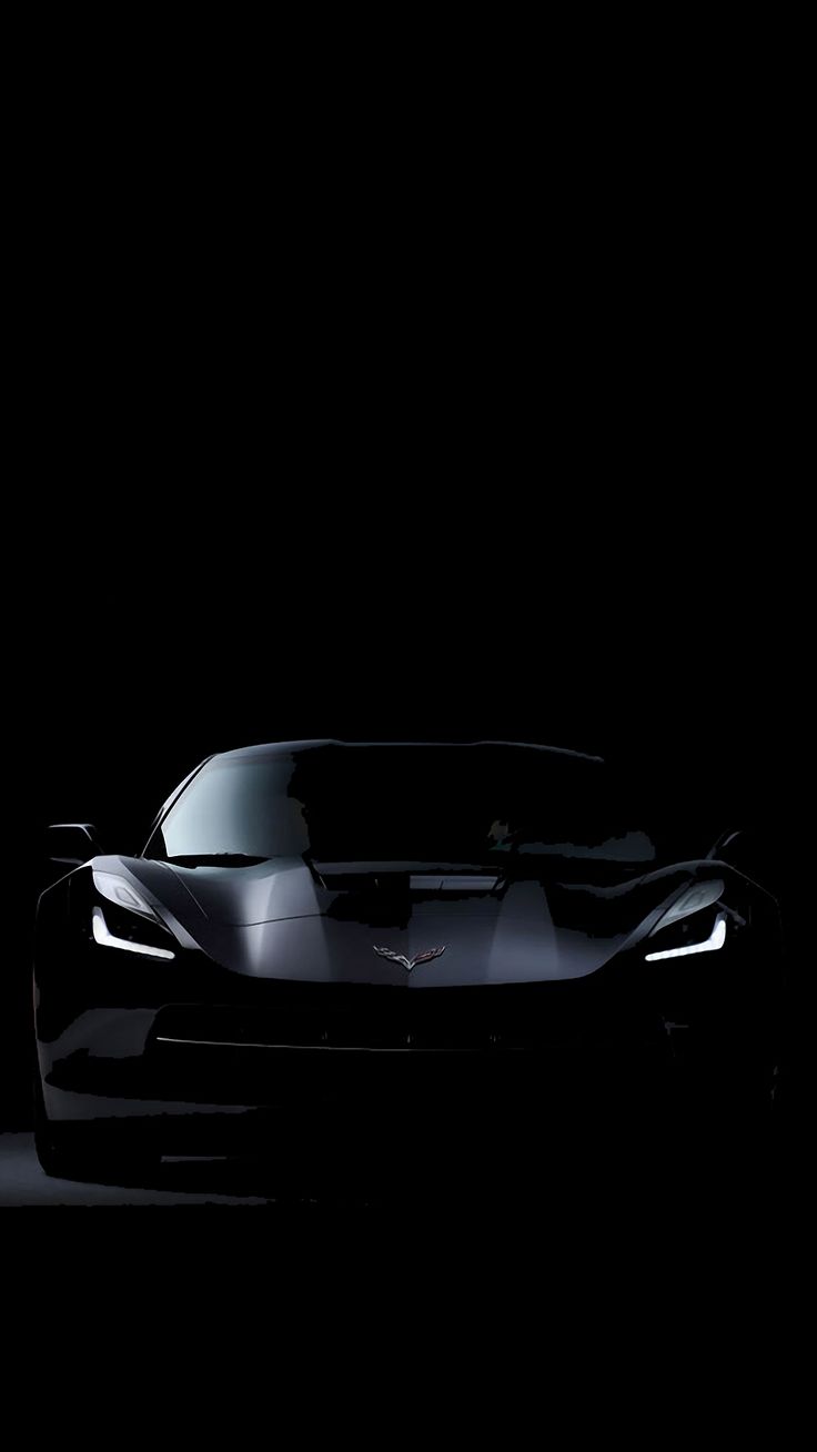 a black sports car is shown in the dark