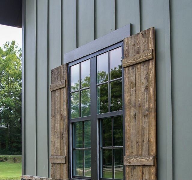 an open window on the side of a building with wooden shutters and stone wall