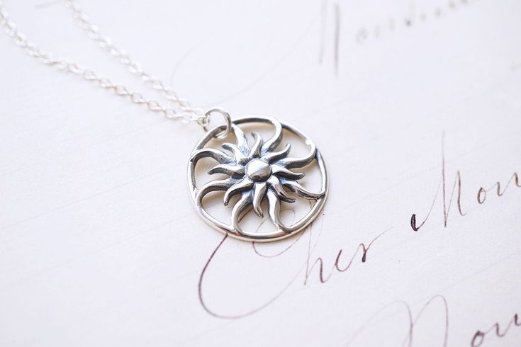 Sterling Silver Rapunzel Sun Necklace, No. SNCC067 :*About This Piece*: ♦︎ This unique piece captures the radiance of the sun in a sterling silver whimsical sun pendant hung on a fine sterling silver chain. The many rayed sun has beautiful details with a smooth symmetry. ♦︎ Length - 18 in (45.7 cm) chain ♦︎ Pendant - .88 in (22 mm) by .75 in (19 mm) ♦︎ Visit my shop for more here: https://www.etsy.com/shop/storygirlcreations ♦︎ All items from my shop are packaged in padded cardboard jewelry boxe Sterling Silver Sun Design Jewelry, Silver Sun Necklace With Sun And Moon Design, Silver Necklace With Sun And Moon Design, Sterling Silver Jewelry With Sun Design, Whimsical Round Sterling Silver Jewelry, Unique Round Jewelry With Sun Design, Silver Sun Design Jewelry As A Gift, Silver Sun Design Pendant Necklace, Unique Round Sun Design Jewelry