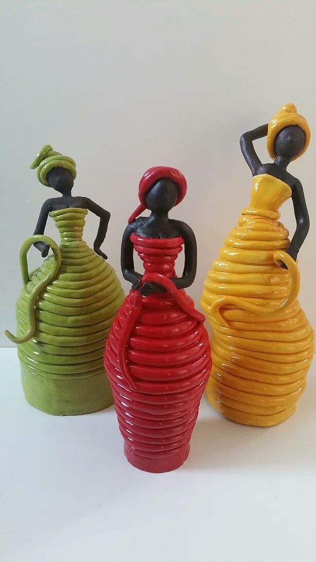 three colorful vases sitting next to each other on a white surface with one holding a red and the other yellow