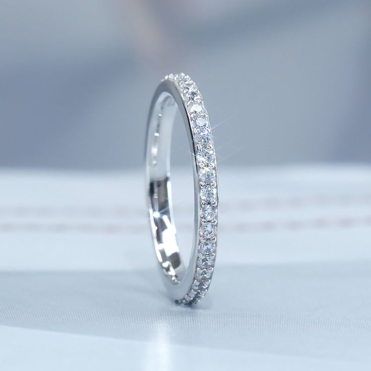 a white gold wedding band with round brilliant cut diamonds on the outside, and inside