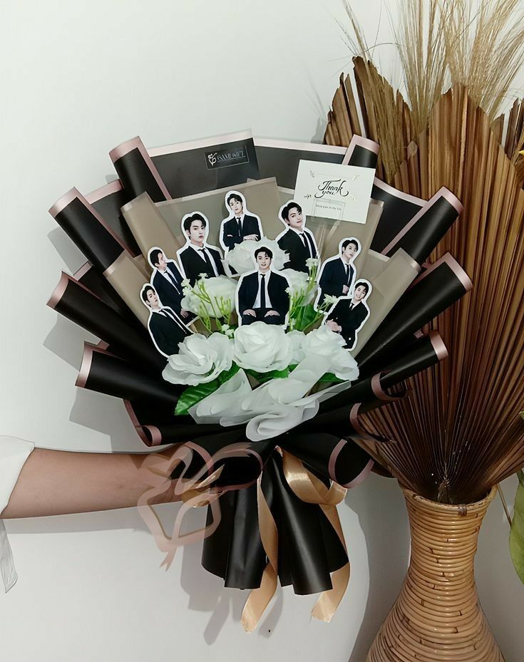 a bouquet of flowers is being held up by someone's hand with pictures on it