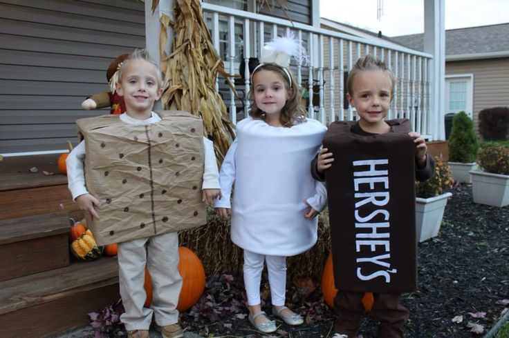 three children dressed up in costumes for halloween