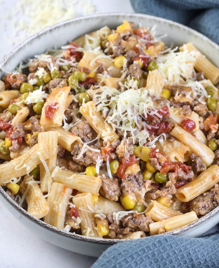 a white bowl filled with pasta and meat