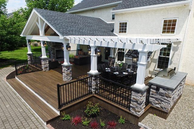 an aerial view of a house with patio and pergolated area in the front yard