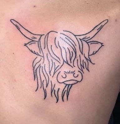 a black and white photo of a bull's head on the back of a woman