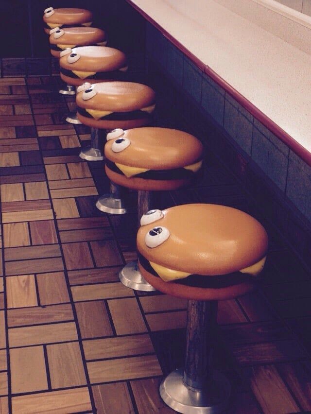 a row of stools with faces painted on them in a diner's restaurant