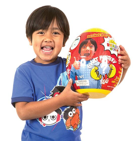 a young boy holding up a large toy