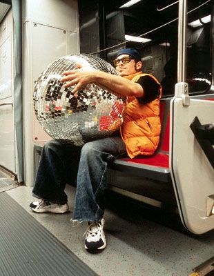 a man sitting on a bus holding a disco ball