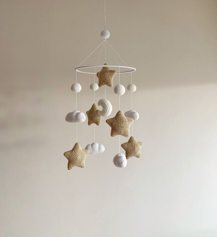 a crocheted star mobile hanging from the ceiling in a room with white walls