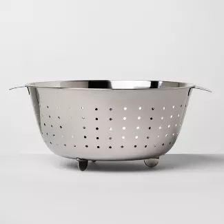 a large metal colander sitting on top of a table