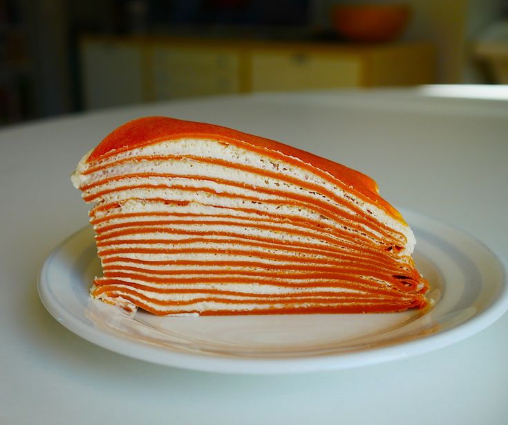 a stack of pancakes sitting on top of a white plate covered in orange icing