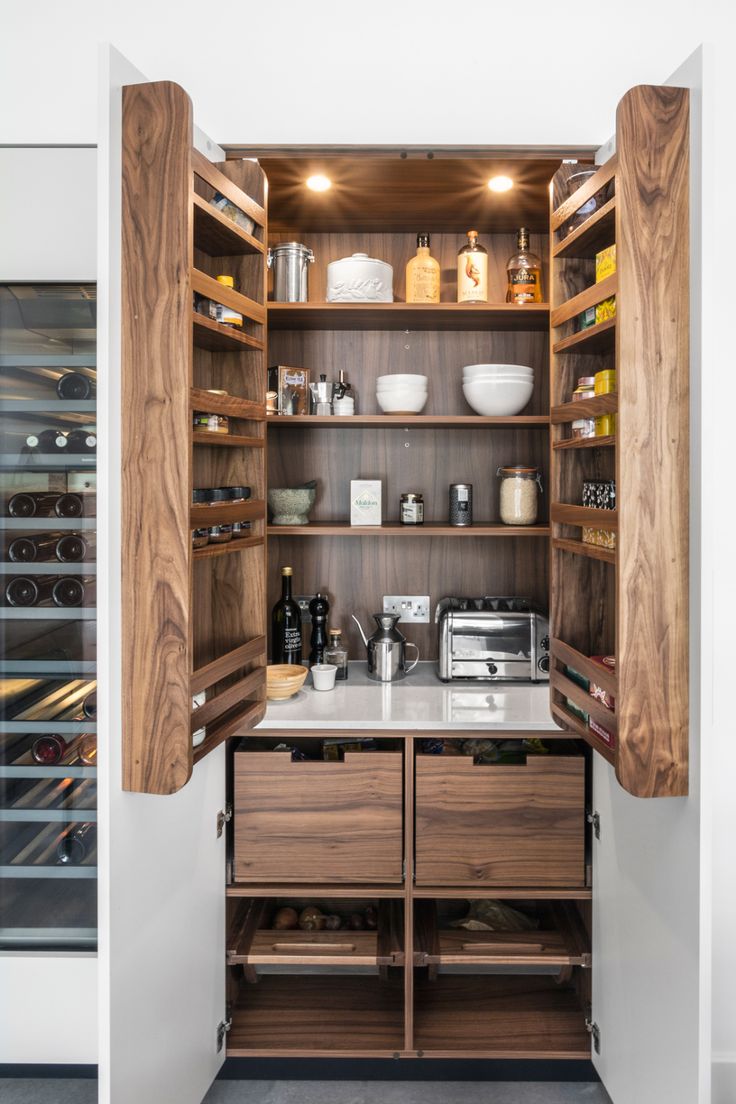 an open pantry with lots of food and wine in it's cupboards on the wall