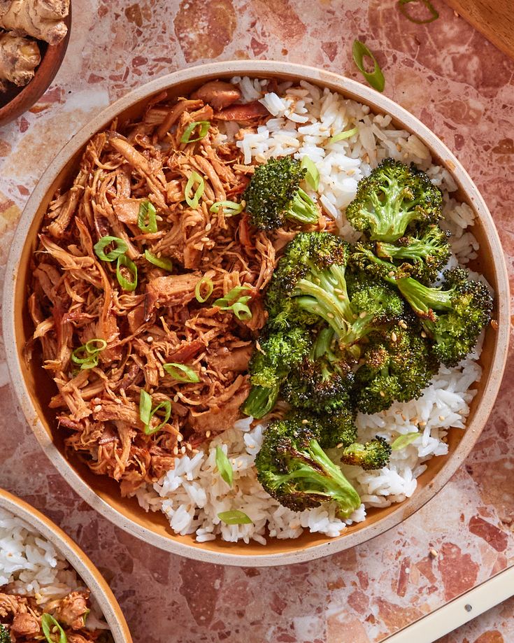 two bowls filled with rice, broccoli and meat