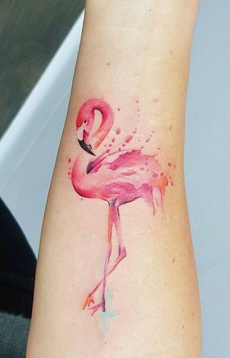 a watercolor flamingo tattoo on the left arm and wrist is shown in pink