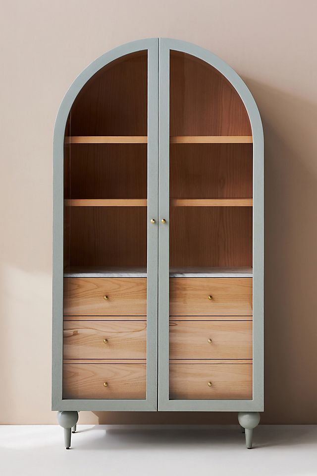 an arched wooden cabinet with drawers in the middle and two doors open on each side